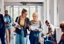 A group of people standing in a room Description automatically generated with low confidence
