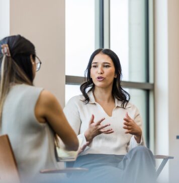 A person sitting on a chair Description automatically generated with low confidence