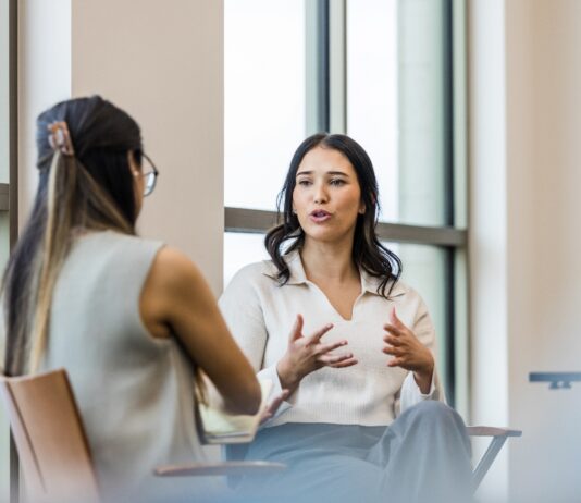 A person sitting on a chair Description automatically generated with low confidence